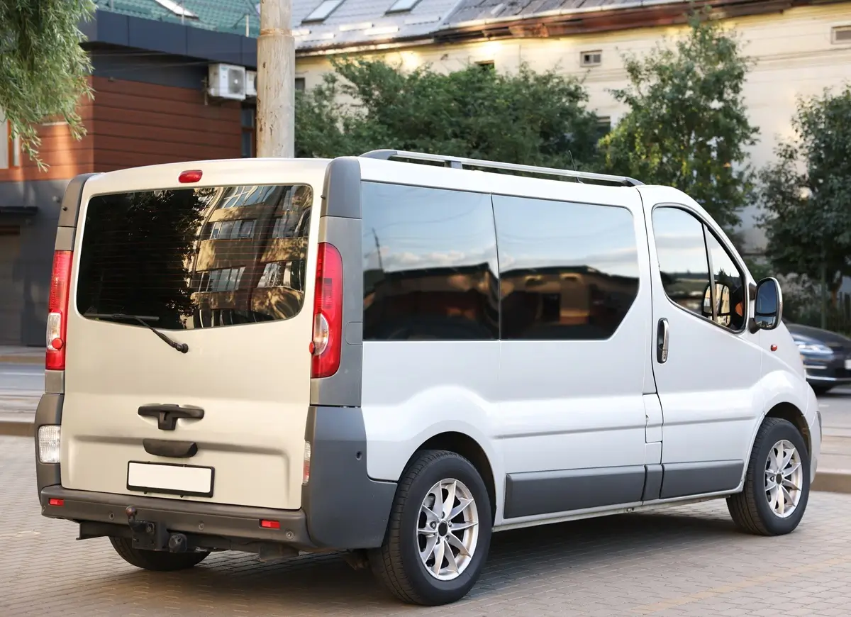 Fleet White 12-seater minibus parked outside a hotel
