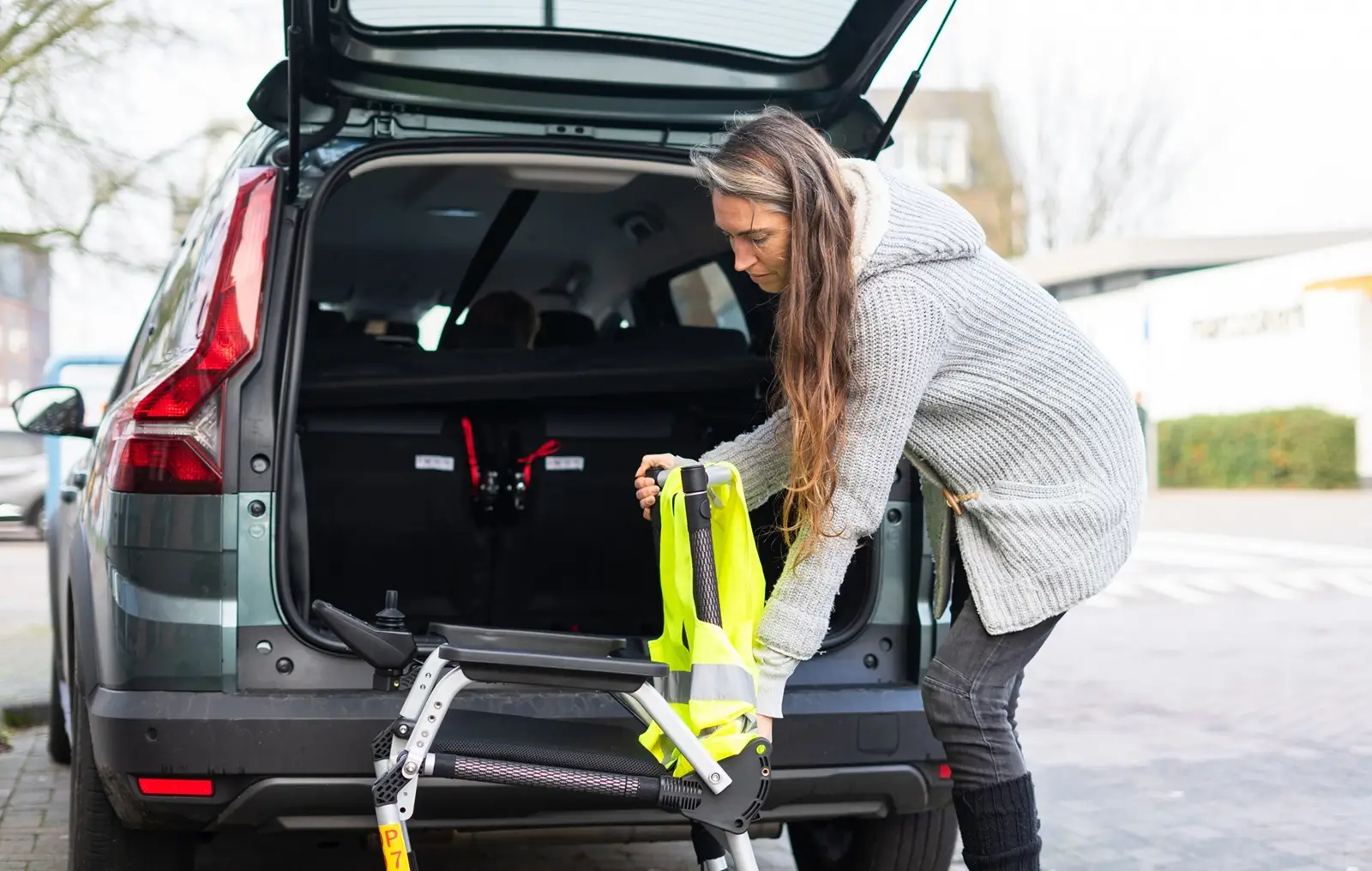 Frimley Taxi Man putting a folded walking frame into the back of a car